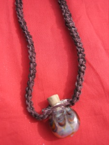 Glass bottle necklace. The stopper comes out so bottle can be filled with sand, soil, tiny beads or stones, a poem, or a love note.