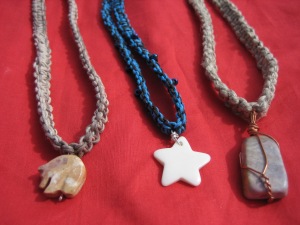 From left to right: stone bear, bone star, polished rock necklaces.