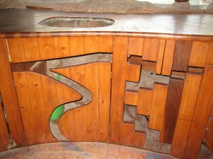 This is the sink area in the kitchen. The doors to the cabinets under the sink are made of wood with cut out designs.